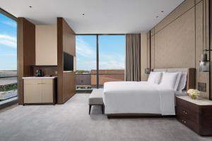 een slaapkamer met een groot wit bed en een groot raam bij Crowne Plaza Shanghai Hongqiao, an IHG Hotel in Shanghai