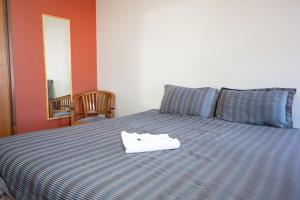 a blue and white bed with a towel on it at Beatty Lodge in Perth