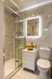uma casa de banho com um chuveiro, um WC e um lavatório. em L'Alcôve Dorée - Appart'Hôtel SPA - Melina & Alfred Agen em Agen