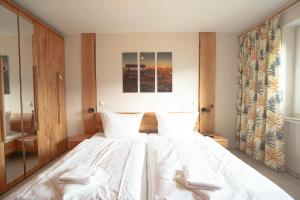 a bedroom with a large bed with white sheets at Lieblingsplatz in Ofterschwang