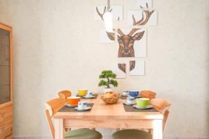 a dining room with a wooden table with chairs and antlers on the wall at Lieblingsplatz in Ofterschwang