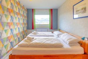 a bedroom with two beds with a colorful wall at Lieblingsplatz in Ofterschwang