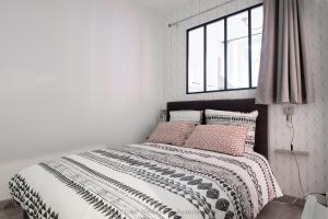 Un dormitorio blanco con una cama con almohadas y una ventana en - Le petit Rochelais - Centre Vieux Port, en La Rochelle