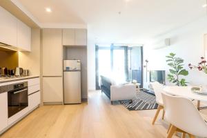 a kitchen and dining room with a table and a refrigerator at KOZYGURU DOCKLANDS MODERN COZY 1 BED ROOM UNIT MELBOURNE VDO628 in Melbourne