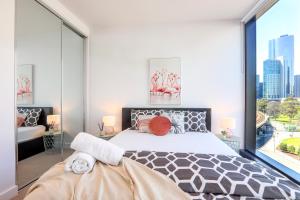a bedroom with a large bed and a large window at KOZYGURU DOCKLANDS MODERN COZY 1 BED ROOM UNIT MELBOURNE VDO628 in Melbourne