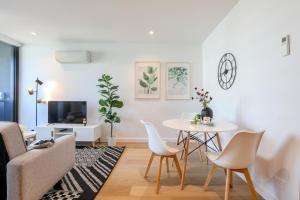 a living room with a table and chairs at KOZYGURU DOCKLANDS MODERN COZY 1 BED ROOM UNIT MELBOURNE VDO628 in Melbourne