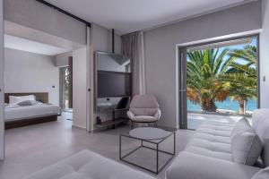 a living room with a couch and a large window at LaLiBay Resort & Spa - Adults Only in Perdika