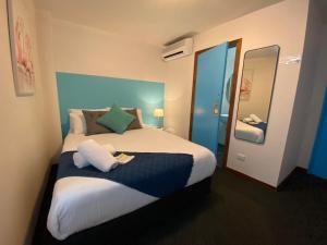 a bedroom with a large bed and a mirror at Nomads St Kilda - Base in Melbourne