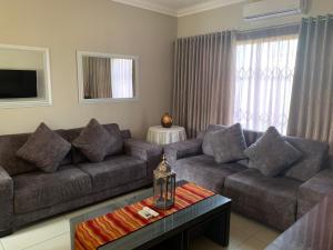 a living room with a couch and a table at Bay Sun Lodge in Richards Bay