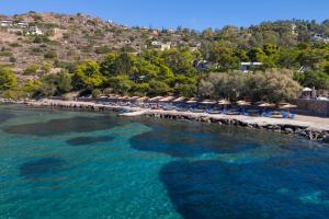a beach with chairs and umbrellas and the ocean at LaLiBay Resort & Spa - Adults Only in Perdika
