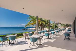 a row of tables and chairs on the beach at LaLiBay Resort & Spa - Adults Only in Perdika