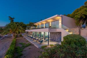 a large house with tables and chairs in front of it at LaLiBay Resort & Spa - Adults Only in Perdika