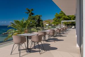 a row of tables and chairs on a patio at LaLiBay Resort & Spa - Adults Only in Perdika