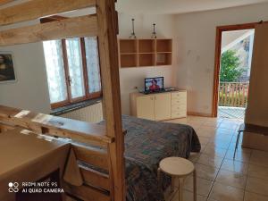 a bedroom with a bed and a tv in a room at Residenza La Ruina in Fenestrelle