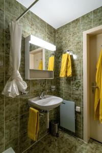 uma casa de banho com um lavatório, um espelho e toalhas amarelas em Fyfauter 1 em Schwarzsee