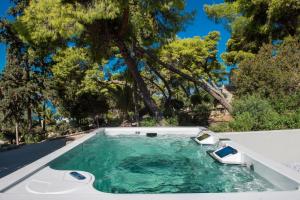 a hot tub in a backyard with trees in the background at LaLiBay Resort & Spa - Adults Only in Perdika