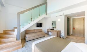 1 dormitorio con cama, sofá y escaleras en Akti Beach Club en Kardámaina