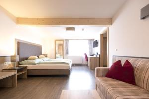 1 dormitorio con 1 cama y 1 sofá en Hotel-Restaurant Planaihof en Schladming