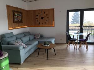 a living room with a blue couch and a table at Ferienwohnungen "Blumenwiese" in Dillingen an der Donau