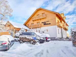 un carruaje tirado por caballos estacionado frente a un edificio en Penzion Maria, en Liptovský Mikuláš