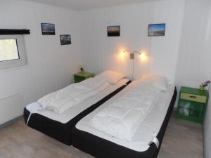 two twin beds in a room with white walls at Blåvand in Blåvand