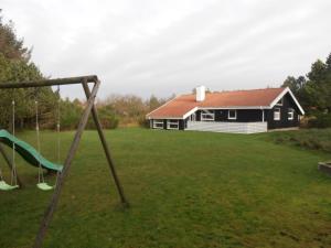 a house with a yard with a swing at Blåvand in Blåvand