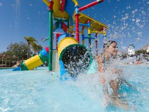uma criança brincando na água em um parque aquático em Magic Natura Resort em Benidorm