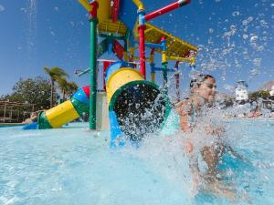 un niño pequeño jugando en el agua en un parque acuático en Magic Natura Resort, en Benidorm