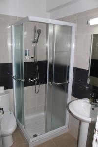 a bathroom with a shower and a toilet and a sink at Tiffany City Apartments in Larnaka