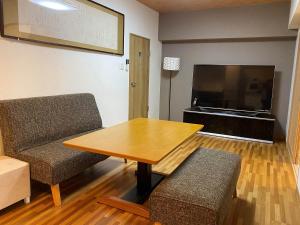 a living room with a table and chairs and a television at Kyoto-Gion Tourist House in Kyoto