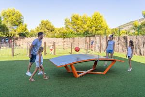 a man and two children standing next to a trampoline at Magic Robin Hood in Albir