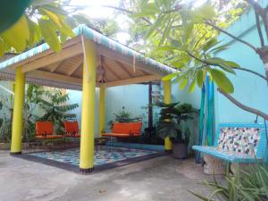 uma pérgola com cadeiras laranja e uma parede azul em Casa Azul - Apartment em San Felipe de Puerto Plata