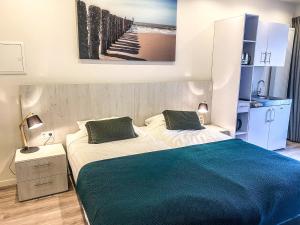 een slaapkamer met een groot bed en een blauwe deken bij Appartement Centrum Domburg DO05 in Domburg