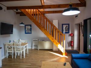a living room with a dining room table and a staircase at Apartamenty Park in Ciechocinek