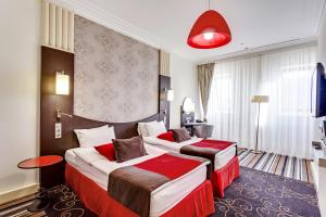 Habitación de hotel con 2 camas y lámpara roja en Mercure Rostov-On-Don Center, en Rostov-on-Don