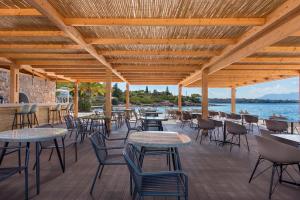 a patio with tables and chairs and the water at LaLiBay Resort & Spa - Adults Only in Perdika