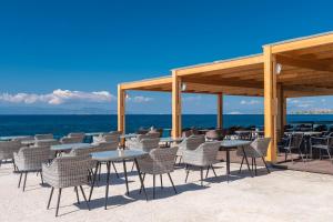 a group of tables and chairs on the beach at LaLiBay Resort & Spa - Adults Only in Perdika