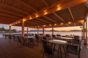 a restaurant with tables and chairs on a deck at LaLiBay Resort & Spa - Adults Only in Perdika