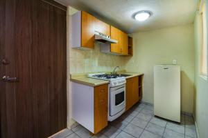 a kitchen with a white stove and a refrigerator at Suites Navata in Guadalajara