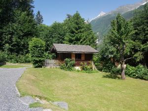 a small house in the middle of a grassy yard at Chalet Alpine Rose in Chamonix-Mont-Blanc