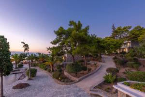 a park with trees and bushes and a house at LaLiBay Resort & Spa - Adults Only in Perdika