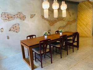 a dining room with a wooden table and chairs at Little One in Chiang Rai