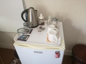a white refrigerator with items on top of it at Valley Guest House in Port Elizabeth
