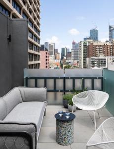 a rooftop patio with a couch and a table at Lancemore Crossley St. Melbourne in Melbourne