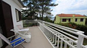a balcony with two chairs and a house at Vacation house Dora in Malinska