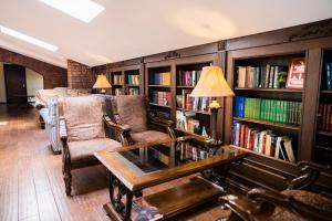 a library with two chairs and a table and books at Rossi Boutique Hotel in Saint Petersburg