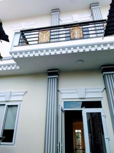 a white house with columns and a balcony at Nhà nghỉ Đế Vương in Thu Dau Mot