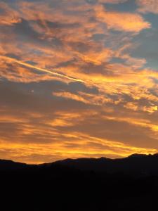 una puesta de sol sobre las montañas en la distancia en B&B Costalta en Compiano