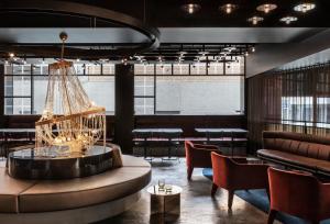 a lobby with a chandelier and a table and chairs at Lancemore Crossley St. Melbourne in Melbourne