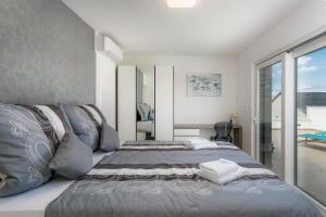 a bedroom with a bed and a large window at Villa LEA MAGDALENA in Malinska +35 photos